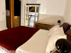 里斯本Castle cozy apartment的一间卧室配有一张床铺,床上铺有红色毯子