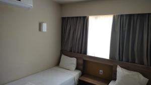 奥林匹亚Solar das Águas - Resort Em Olimpia - Ap 2 quartos的一间卧室设有两张床和窗户。