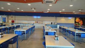 奥林匹亚Solar das Águas - Resort Em Olimpia - Ap 2 quartos的一间设有一排桌子和蓝色椅子的餐厅