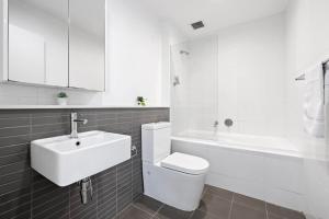 悉尼NEW 3BR Apt in Kingsgrove Sleeps 7的浴室配有卫生间、盥洗盆和浴缸。