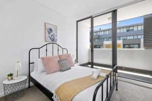 悉尼NEW 3BR Apt in Kingsgrove Sleeps 7的一间卧室设有一张床和一个大窗户