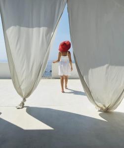 RinellaSalina Castel Vinci的穿着白色衣服和红帽的女子在船上行走