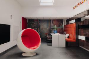 马斯特里赫特马斯特里赫特设计酒店的一间客厅,客厅里配有红色椅子