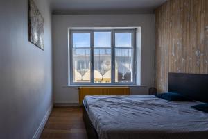 滨海布洛涅L Etoile de Boulogne proche plage et nausicaa的一间卧室设有一张床和一个大窗户
