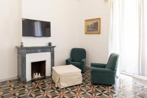加利波利Palazzo Grassi的客厅配有两把椅子和壁炉