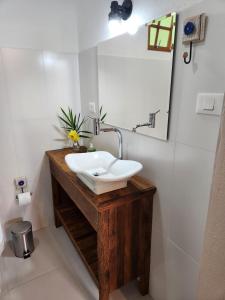 库尼亚POUSADA SERTÃO DA BOCAINA的木制柜台上带白色水槽的浴室