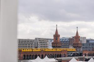 柏林Homaris East Side Hotel - Mobile Key Access的享有黄色火车的城市美景