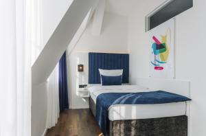 柏林Homaris East Side Hotel - Mobile Key Access的一间卧室配有一张带蓝色毯子的床