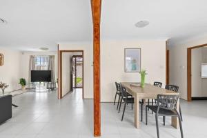 悉尼Beautiful Home In Milperra Sleeps 8的一间带桌椅和电视的用餐室