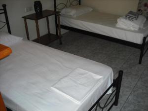 拉基索拉Kostas--Sarantis--2的配有白色床单的客房内的两张床