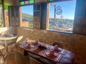 伦索伊斯Hospedaria do Tom的一间带桌椅和窗户的用餐室