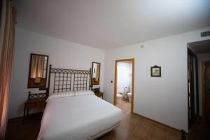 卡斯蒂列哈德拉库埃斯塔HOTEL HACIENDA SANTA BARBARA的卧室配有白色的床和镜子