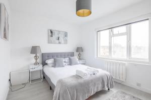 剑桥Lovely 2 bedroom apartment - ideal location的白色的卧室设有床和窗户