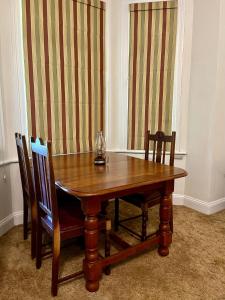 霍维克Heritage Haven的窗帘间里的一张木桌和椅子