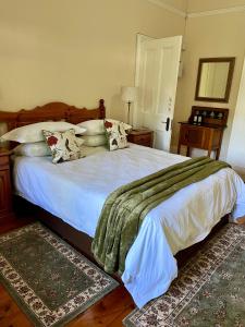 霍维克Heritage Haven的卧室配有一张带白色床单和枕头的大床。