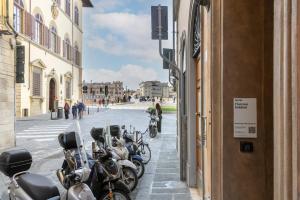 佛罗伦萨Numa Florence Goldoni的停在建筑物外的一排摩托车
