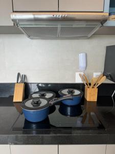 萨尔瓦多Apartamento em Ondina com acesso à praia (Beach Class Salvador)的厨房炉灶上放有2个锅碗瓢盆