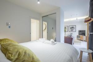 剑桥Luxury City Centre Apartment的一间带白色床的卧室和一间客厅