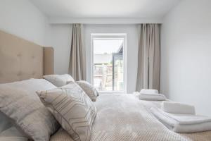 剑桥Luxury 2 Bedroom Apartment with AC and Parking的白色的卧室设有床和窗户