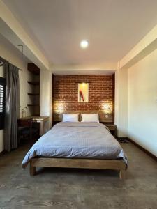 帕坦Shahi Studio Apartment的一间卧室设有一张床和砖墙