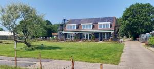 德克瓦克Huis over de dijk的一座房子,在院子里设有太阳能屋顶