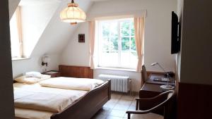 博伦多夫Burg Bollendorf by PRISMA的一间卧室配有一张床、一张书桌和一个窗户。
