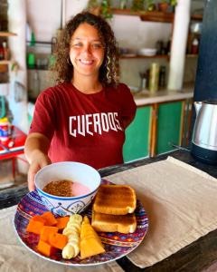 奥尔沃克斯岛Barco Verde Hostel的女人拿着一盘带汤的饭