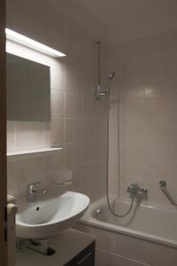 朗斯Family friendly 2-Bedroom near Golf & Ski slopes的浴室配有水槽、淋浴和浴缸。