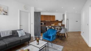 伯明翰Priority Suite - Modern 2 Bedroom Apartment in Birmingham City Centre - Perfect for Family, Business and Leisure Stays by Estate Experts的带沙发和蓝椅的客厅