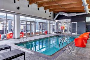绿湾绿湾酒店的一座带红色椅子的建筑中的游泳池