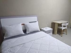 塔那那利佛Milestone City - Appartements à louer的白色卧室配有床和书桌
