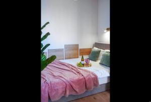 托伦4 Styles Apartment Rose z miejscem postojowym w garażu podziemnym的一间卧室配有一张带粉色毯子的床