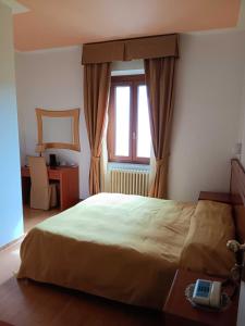 奥维多皮齐欧酒店的一间卧室配有一张带窗户的床和一张书桌