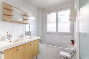 皮托Residor - Warm appartement near Paris的一间带水槽和浴缸的浴室以及窗户。