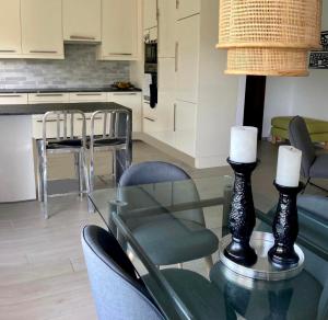 PullyLausanne/Pully: appartement moderne et très bien situé的厨房以及带玻璃桌和椅子的用餐室