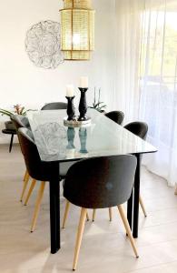PullyLausanne/Pully: appartement moderne et très bien situé的餐桌,配有黑色椅子和玻璃顶
