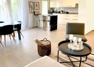 PullyLausanne/Pully: appartement moderne et très bien situé的一间带桌椅的客厅和一间厨房