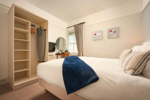 圣奥斯特尔拉希累埃姆斯酒店的卧室配有白色的床和蓝色毯子