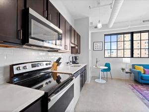 匹兹堡CozySuites Modern 1BR, Downtown Pittsburgh的一间带炉灶的厨房 桌子旁的顶部烤箱