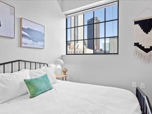 匹兹堡CozySuites Modern 1BR, Downtown Pittsburgh的卧室设有白色的床和大窗户