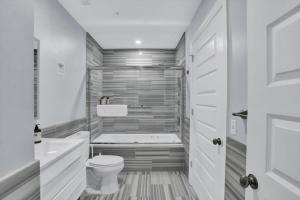 匹兹堡CozySuites Spacious 2BR, PPG Paints Arena, Pitts的白色的浴室设有浴缸和卫生间。