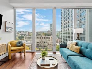 匹兹堡CozySuites 1BR, PPG Paints Arena, Pitts的客厅设有蓝色的沙发和大窗户