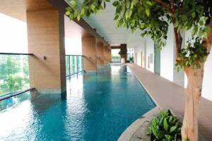 雅加达Apt Capitol Suite Senen 2 BR with Pool & Wifi的蓝色建筑中的一个大型游泳池