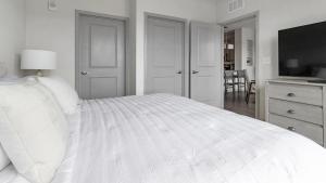MiddleburgLanding Modern Apartment with Amazing Amenities (ID1239X542)的白色卧室设有白色的床和厨房