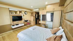 雅加达Tamansari Hive Cawang by Villaloka的一间卧室配有一张床和一台电视