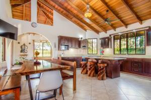 瓜纳卡斯特Villa Roble Alto的厨房设有木制天花板和桌椅