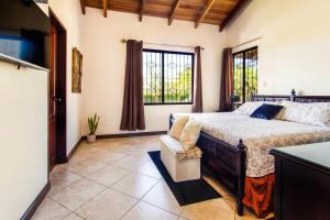 瓜纳卡斯特Villa Roble Alto的一间卧室设有一张床和一个大窗户