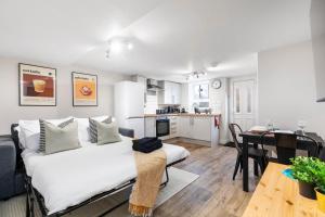 利兹Cosy One Bed Apt in Leeds City的一间卧室配有一张床,厨房配有桌子