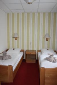 Belgershain金冠酒店的一间设有两张床铺和毛巾的房间