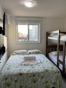 嘎林海斯港Portoparadise - Mandakaru Residence Flat 10的一间卧室配有一张床、一个窗口和双层床